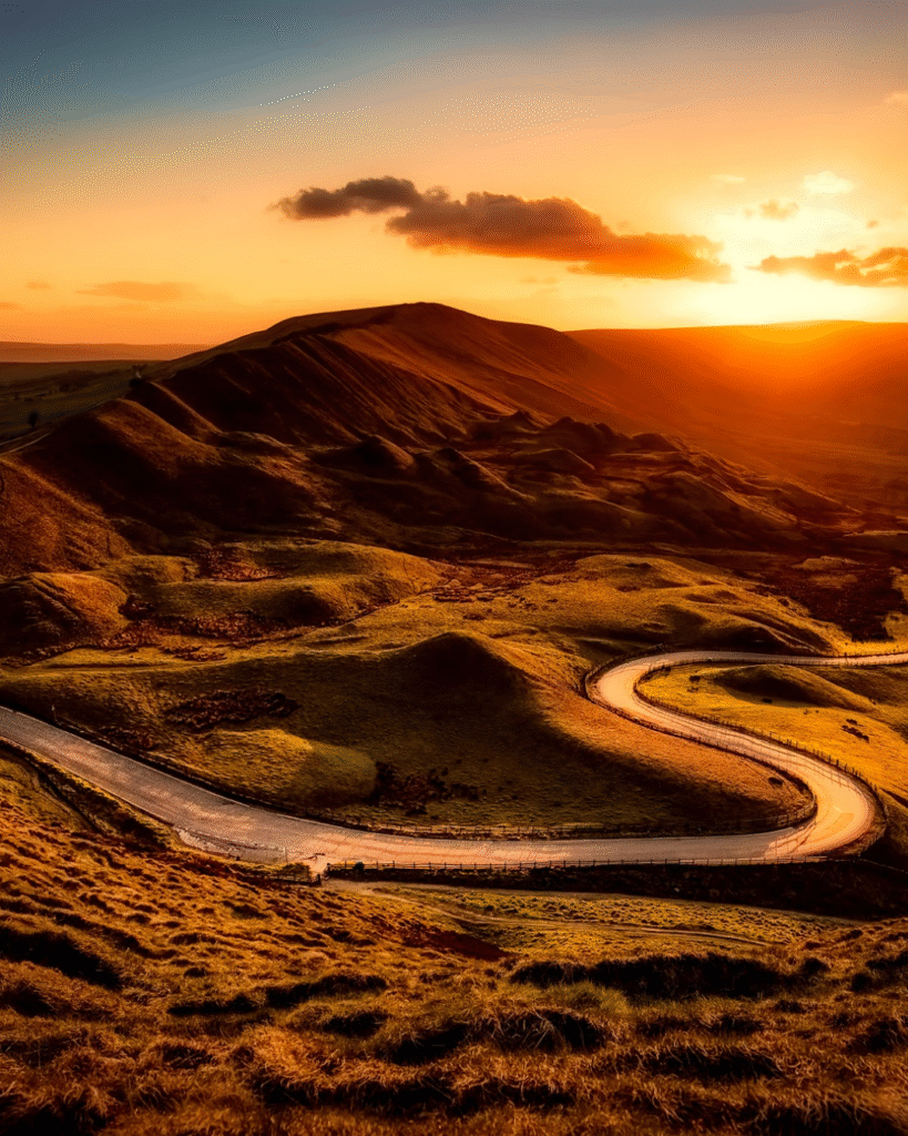 Estrada entre montanhas ao amanhecer representando as transformações e recomeços da vida.